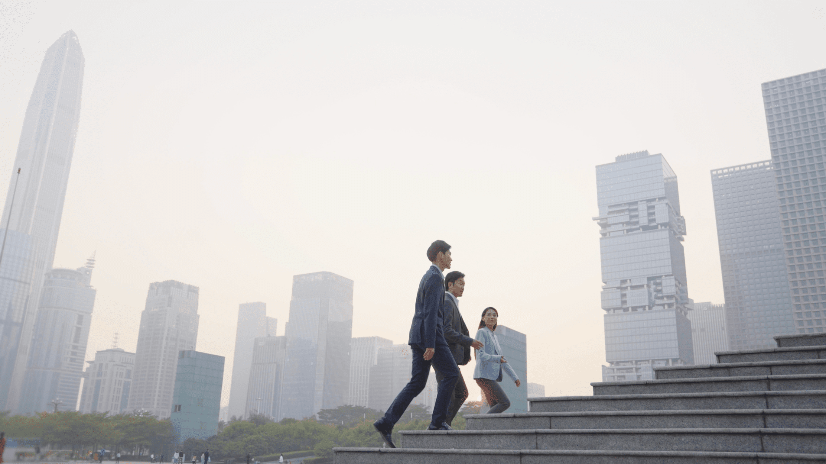 Three office workers chatting while walking up a flight of stairs. 