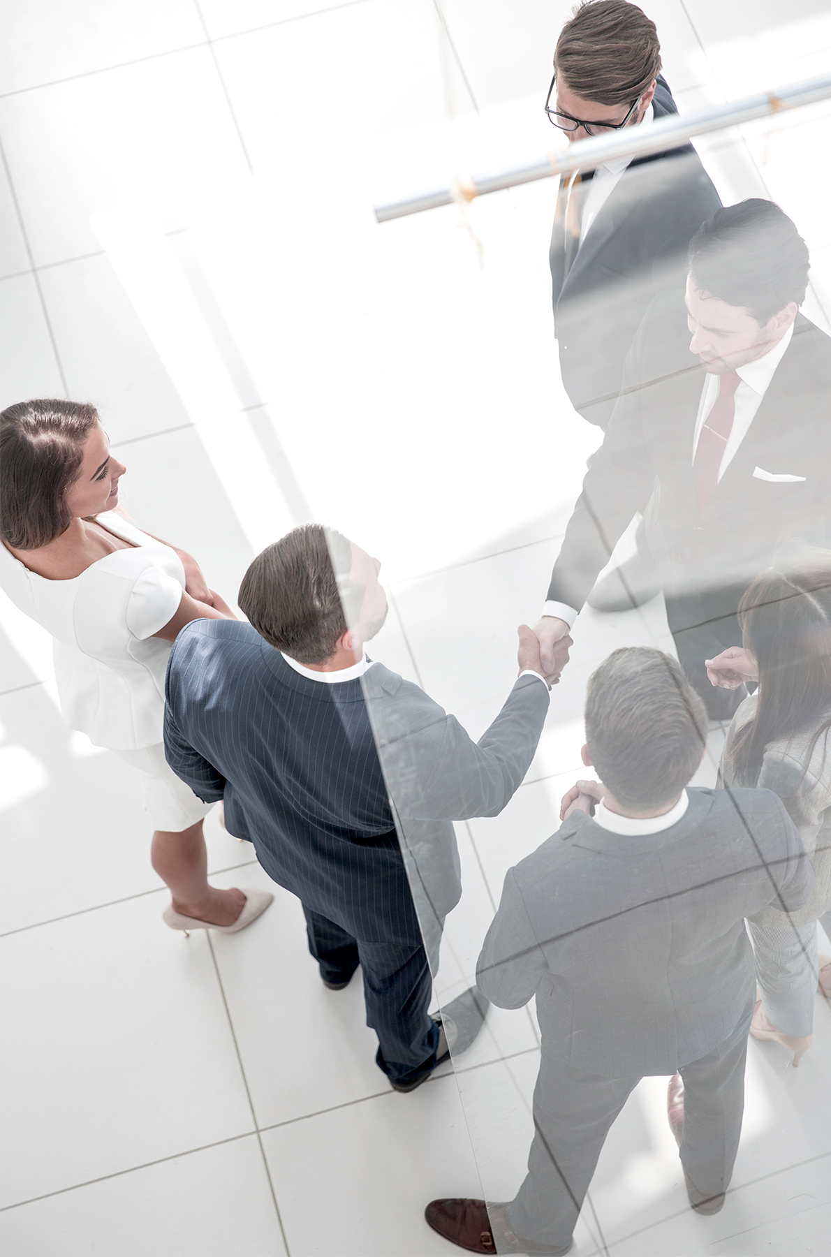 A group of business executives meeting up., with 2 guys shaking hands